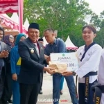 Ketgam : Bupati Konawe Yusran Akbar di dampingi wakil bupati Samsul Ibrahim saat menyerahkan Piagam dan uang tunai secara simbolik. Usai upacara bendera. Selasa, 28/10/2025.