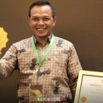 Bupati Konawe, H. Yusran Akbar saat menunjukan plakat dan piagam penghargaan UHC Award 2026 dari BPJS Kesehatan RI.